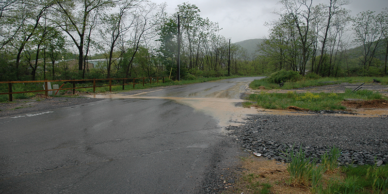 Muddy water flowing across public road